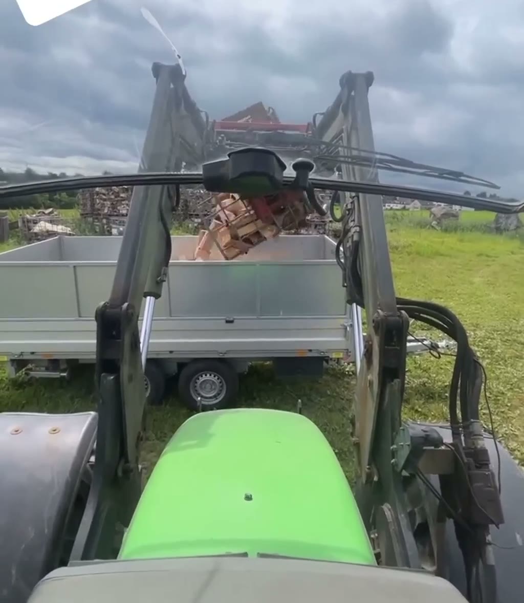 Blick vom Traktor auf den mit Brennholz beladenen Anhänger